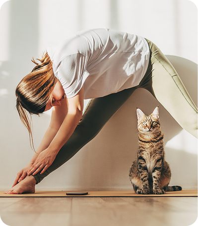 Personne faisant du stretching avec un chat, symbolisant la prévention