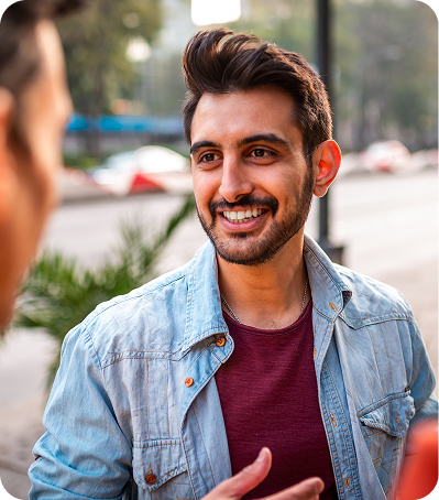Homme souriant en discussion, représentant la protection collective